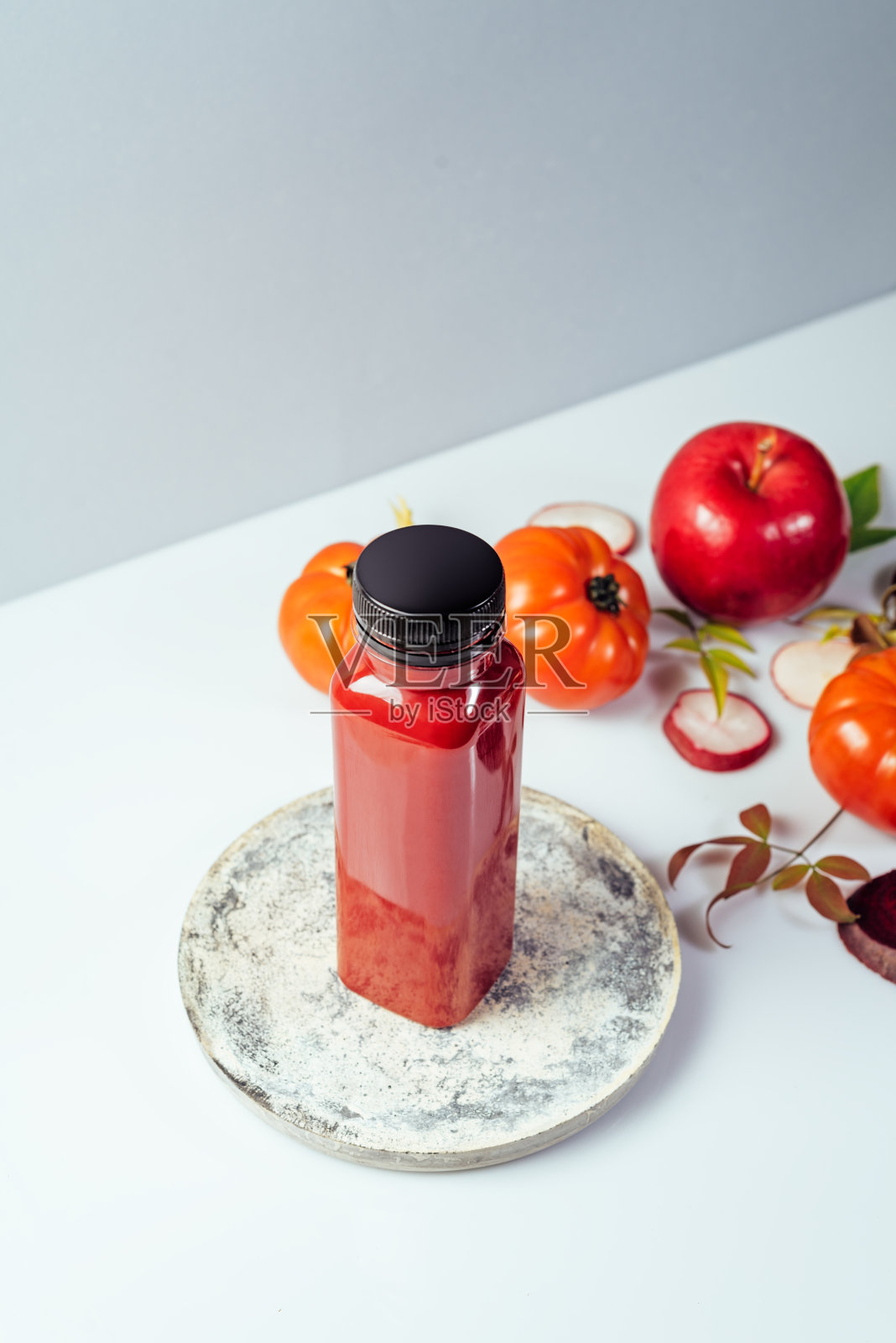 红色冰沙饮料在瓶子包围红苹果，西红柿和甜菜，正面视图照片摄影图片