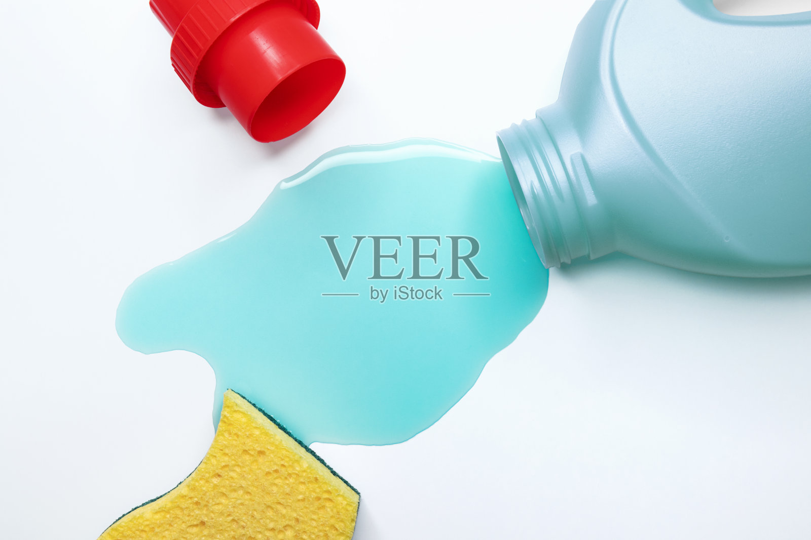 蓝色液体清洁剂洒在桌子上，特写照片摄影图片