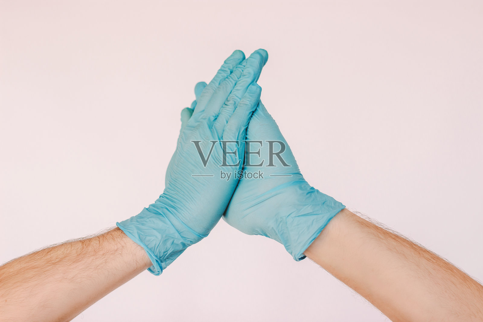 2019冠状病毒病新型安全问候，戴手套鼓掌，实现社交距离照片摄影图片