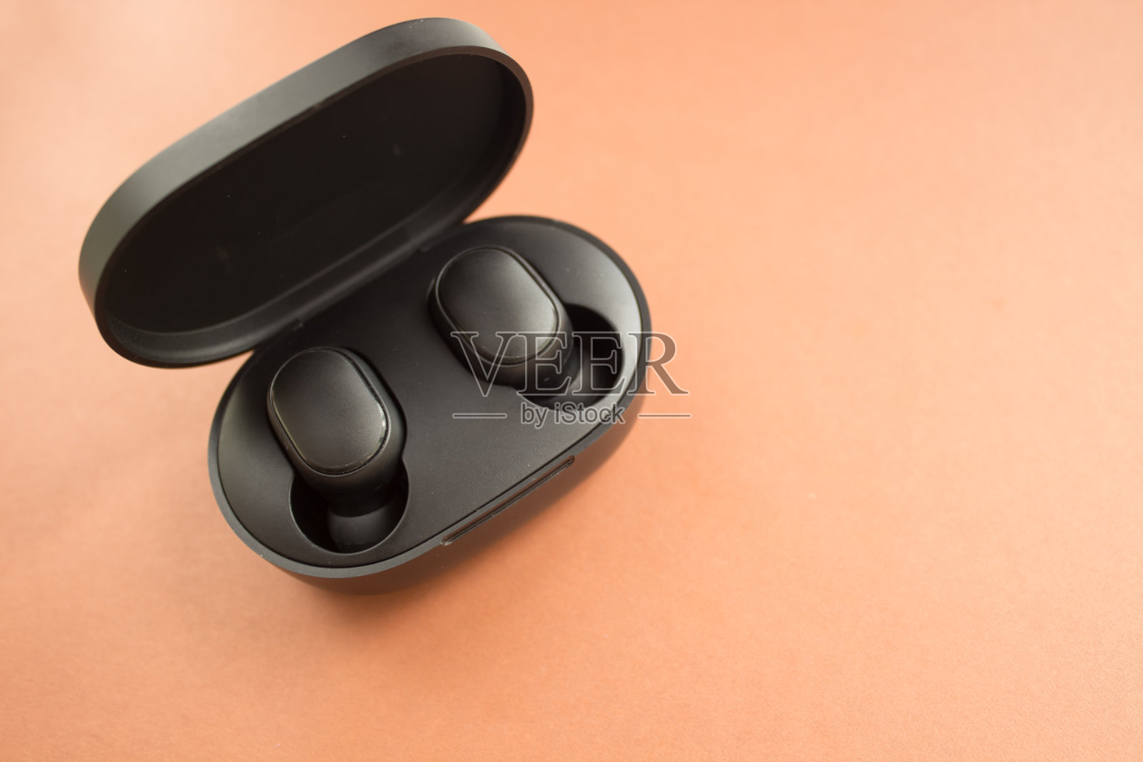 无线和有线耳机可供选择。棕色的背景。前视图。模拟。平躺组成照片摄影图片