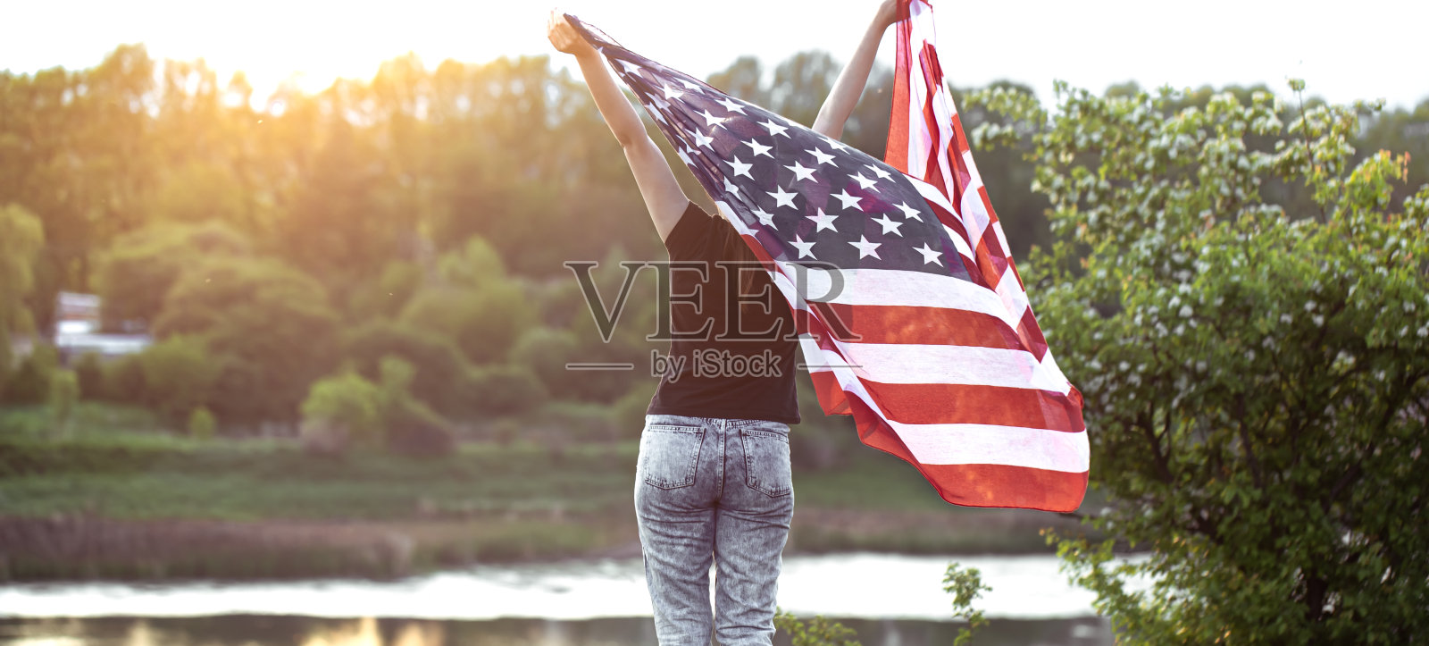 一个手持美国国旗的年轻女子。照片摄影图片