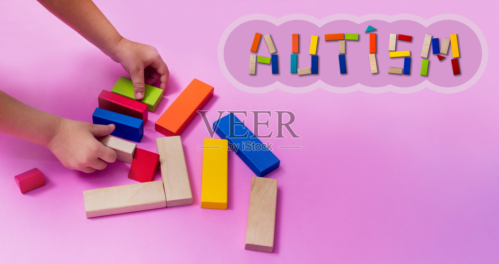 患有自闭症谱系障碍的孩子用木制积木搭建房子。自闭症概念照片摄影图片