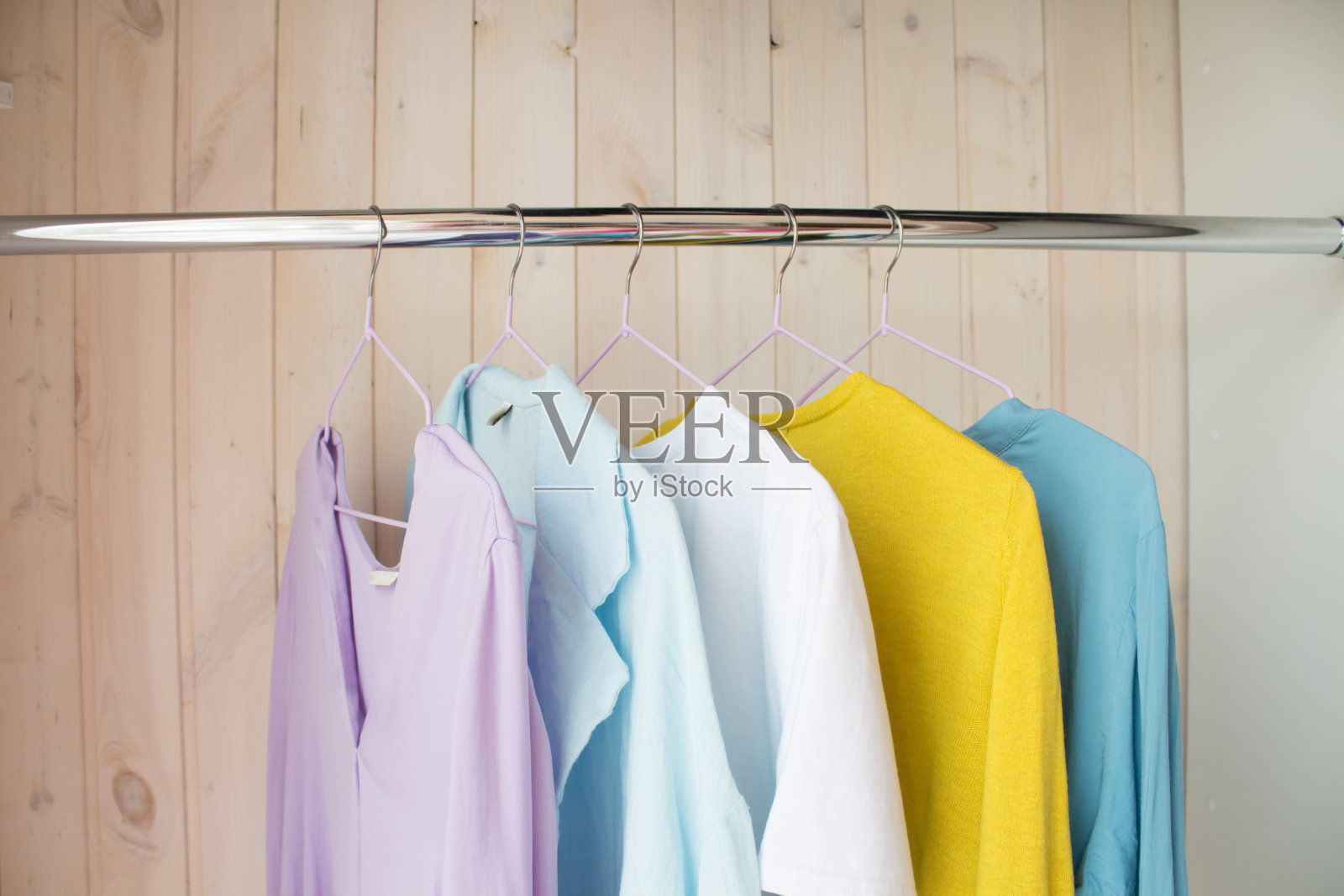 冬天的衣服放在衣柜里的衣架上。清洗冬天的衣服直到下个季节照片摄影图片