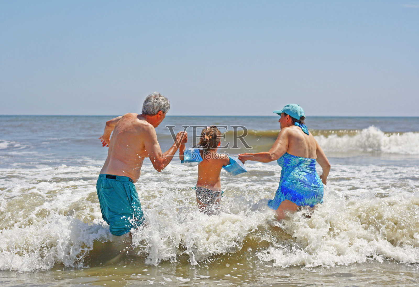50岁以上的男女和孩子在海里玩耍。照片摄影图片