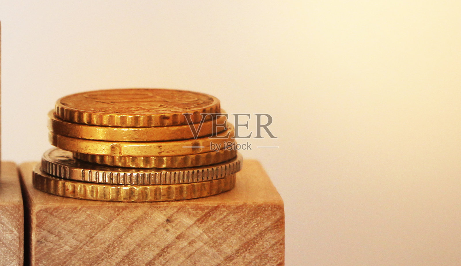 把硬币堆在带有拷贝空间的木方块上。金融概念照片摄影图片