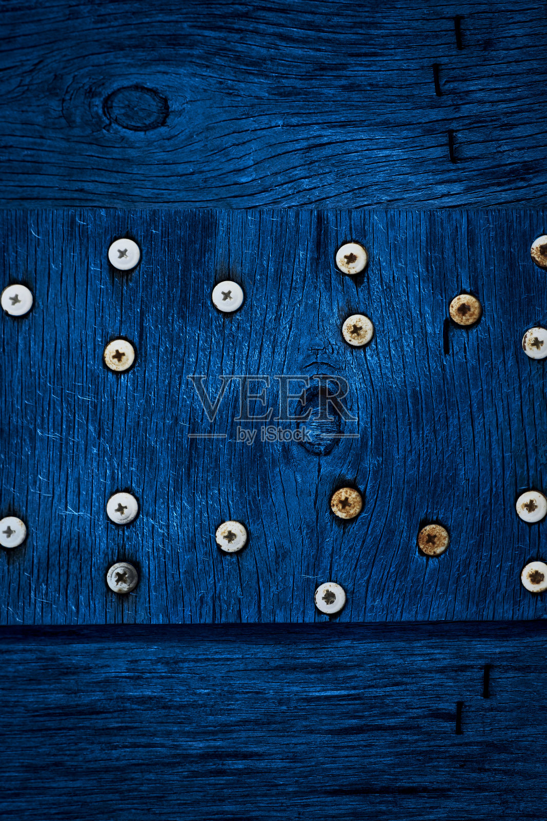 深蓝色的木材和旧螺丝的纹理。旧干燥胶合板的纹理。经典的蓝色背景设计。照片摄影图片