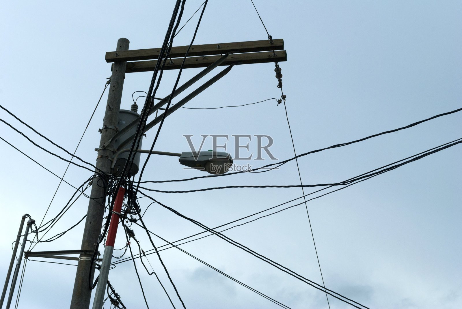 拉丁美洲街道公共灯杆、照明灯具和高压电缆。照片摄影图片