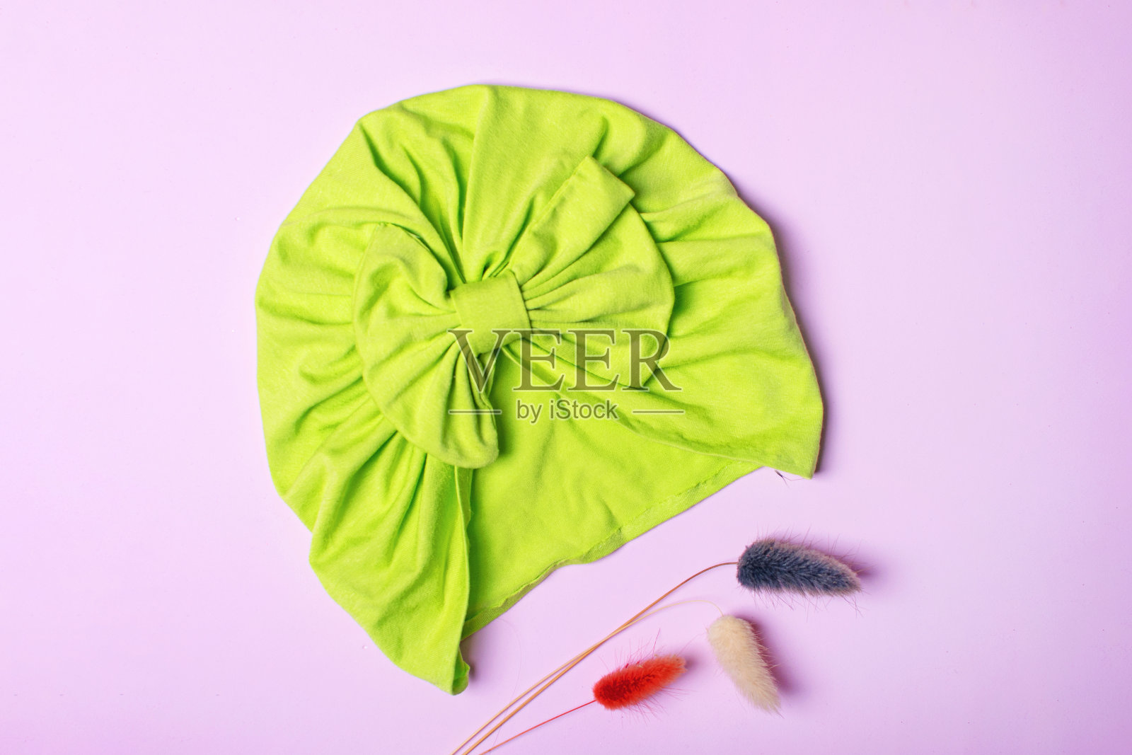 粉色背景的可爱的儿童头巾或头巾。照片摄影图片