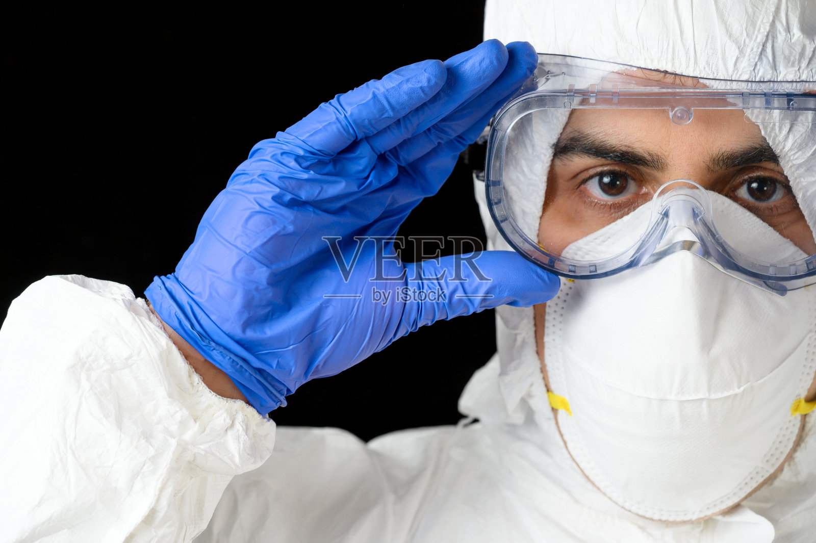 Covid-19防护设备。医生或男护士的肖像穿着个人防护装备在黑色孤立的背景。照片摄影图片