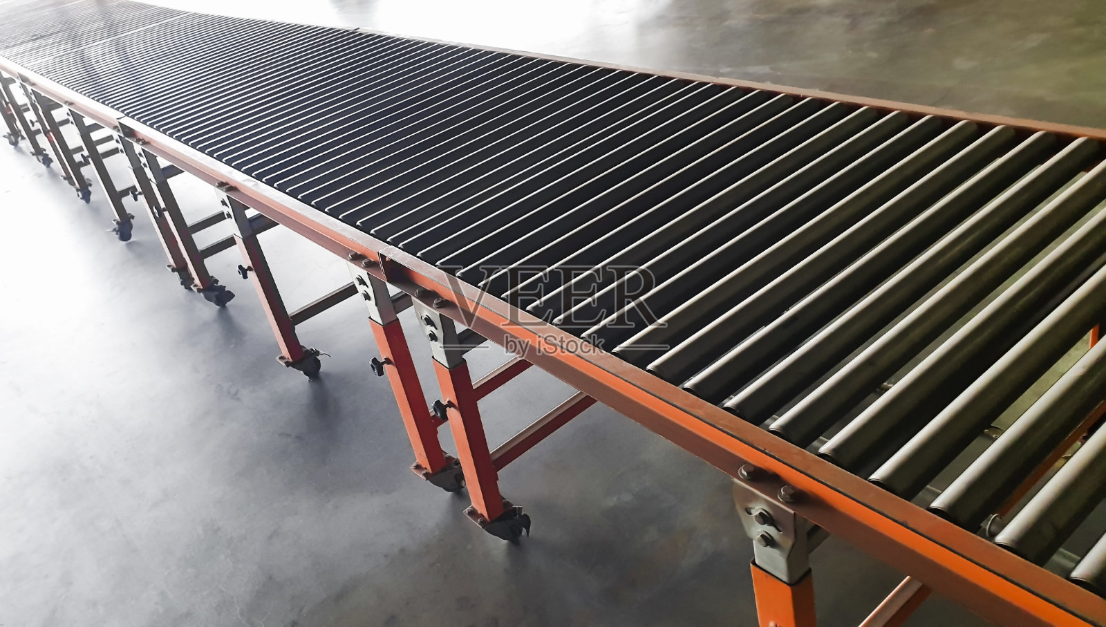 钢辊在仓库输送带上。照片摄影图片