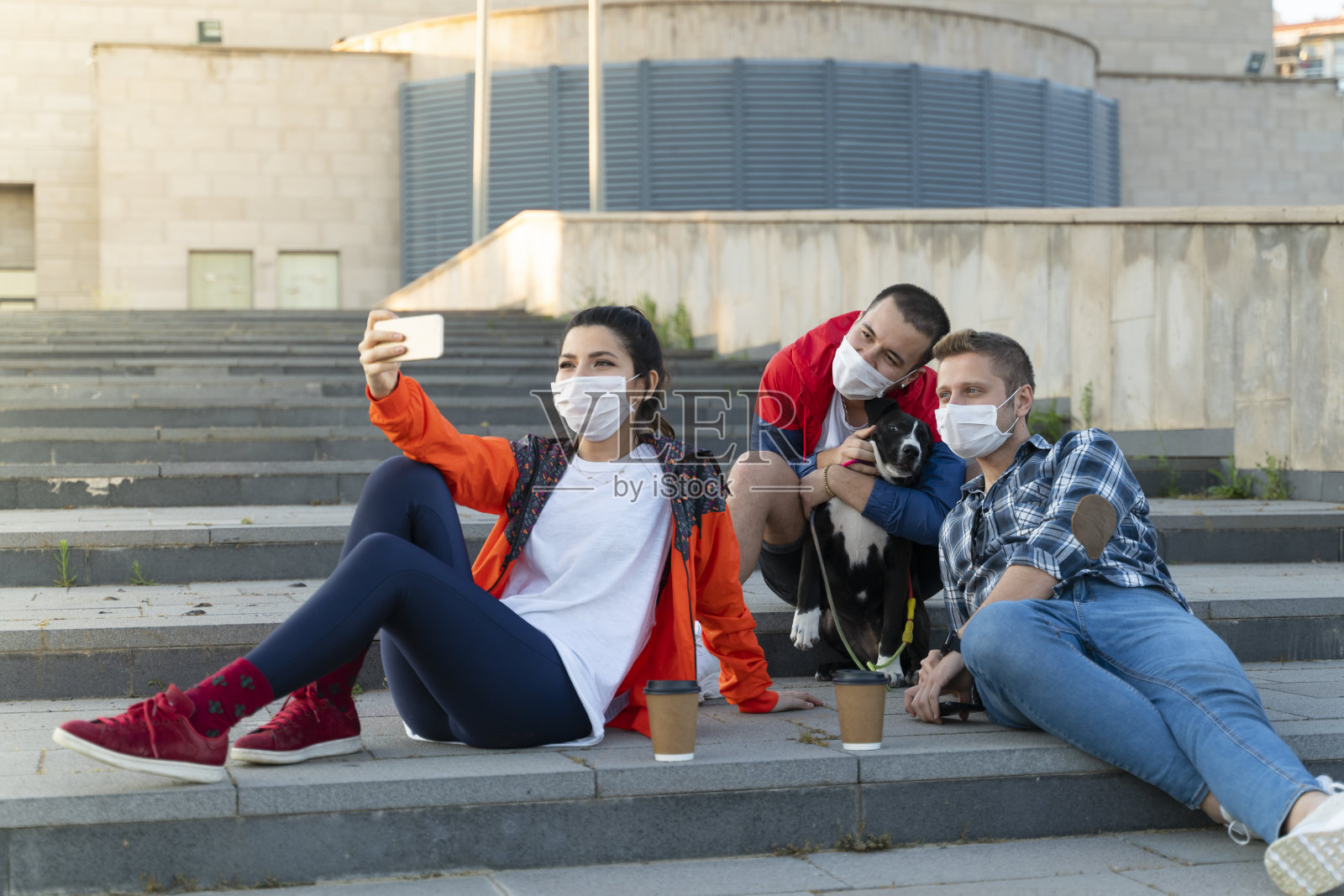 兴高采烈的大学生与朋友坐在台阶上自拍照片摄影图片