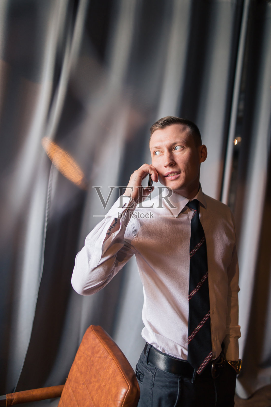 商人正在用智能手机打电话。照片摄影图片