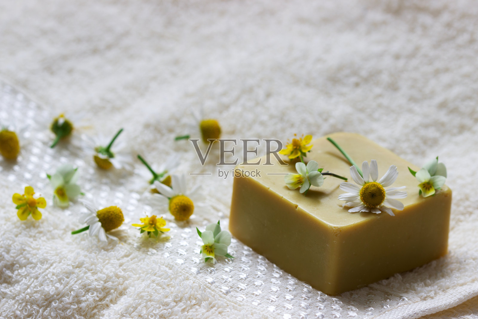 用草药、鲜花和毛巾手工制作的肥皂。照片摄影图片