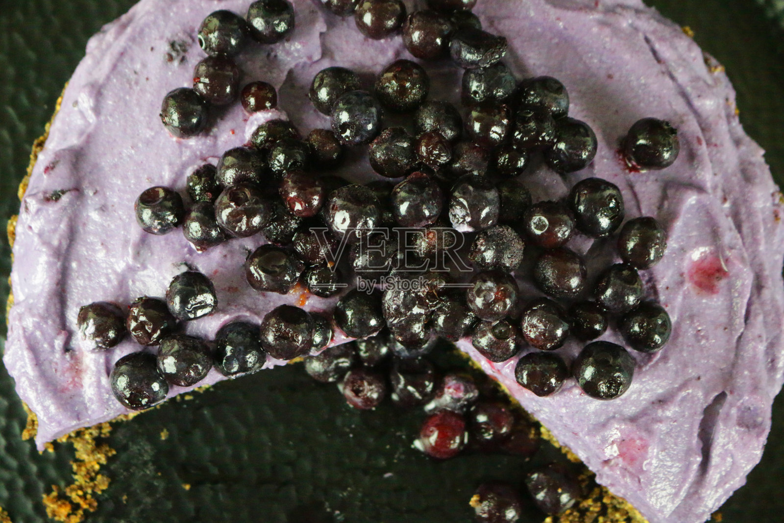 切片蓝莓芝士蛋糕，以黄油饼干为底色，蓝莓马斯卡彭奶油芝士甜点布丁，上面点缀着新鲜的蓝莓照片摄影图片