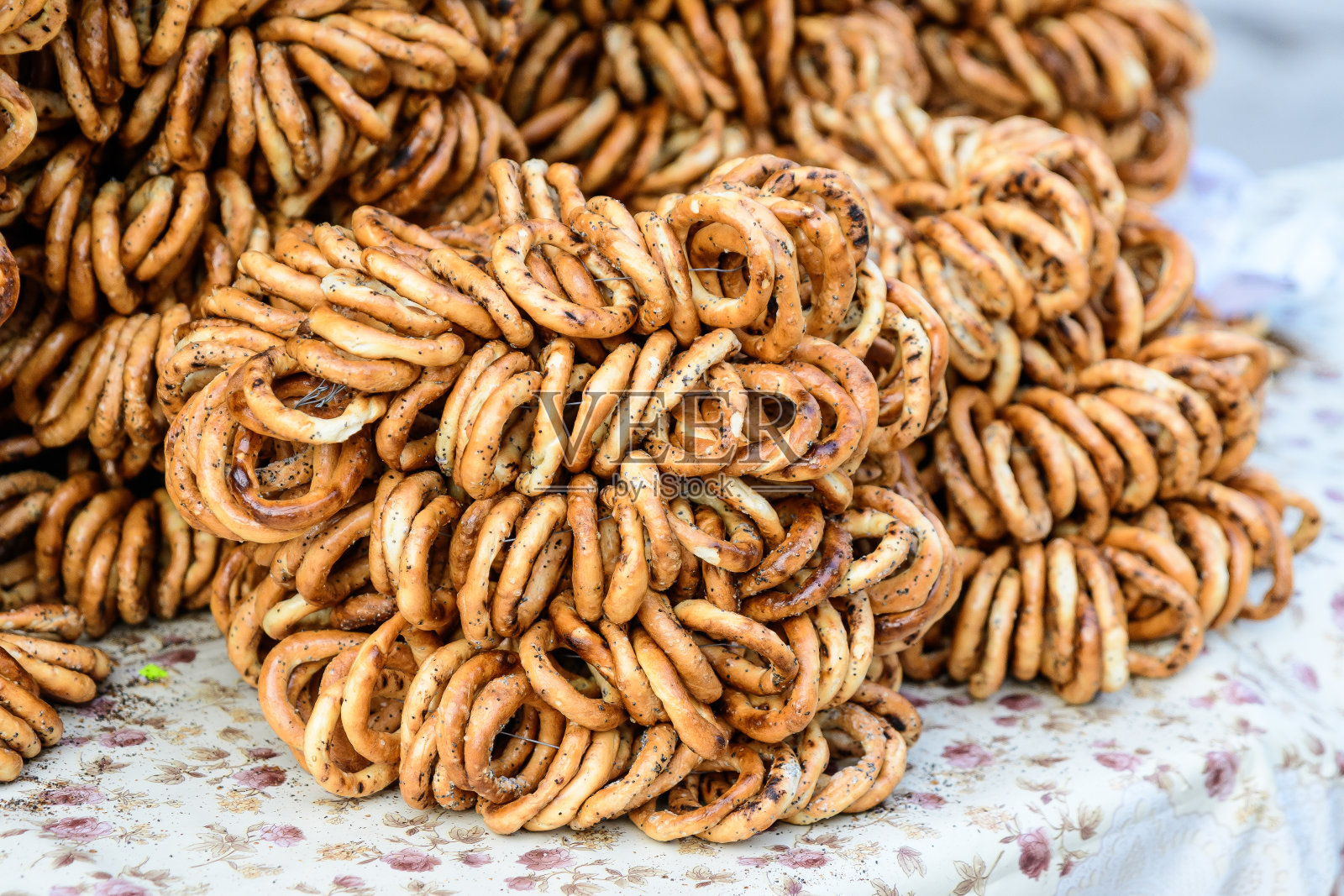 一组用绳子绑在桌子上的干薄椒盐卷饼，在一个食品市场节日，传统食品照片摄影图片
