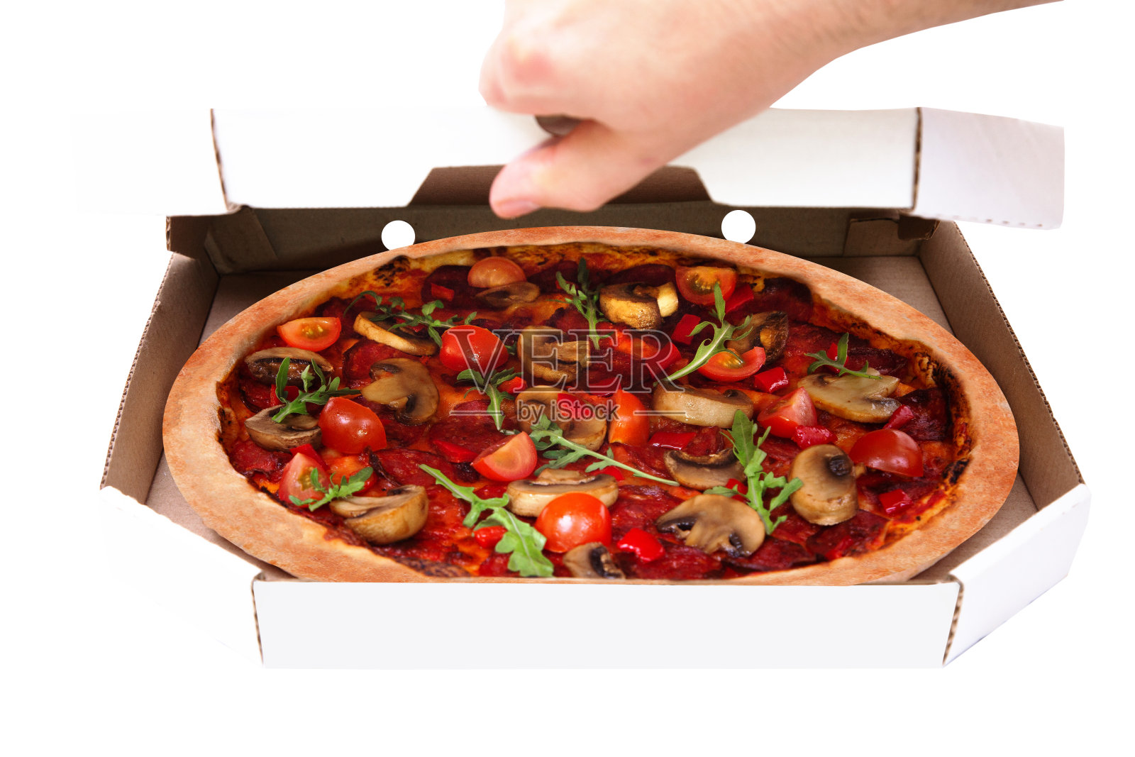 男人打开纸板箱。美味的披萨，辛辣的意大利腊肠，芝麻菜，樱桃番茄，蘑菇和德州混合香料，孤立的白色照片摄影图片