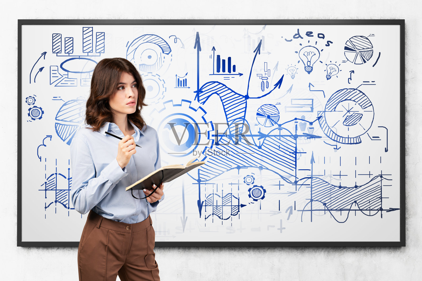 女商人拿着笔记本，在白板上画着图表照片摄影图片