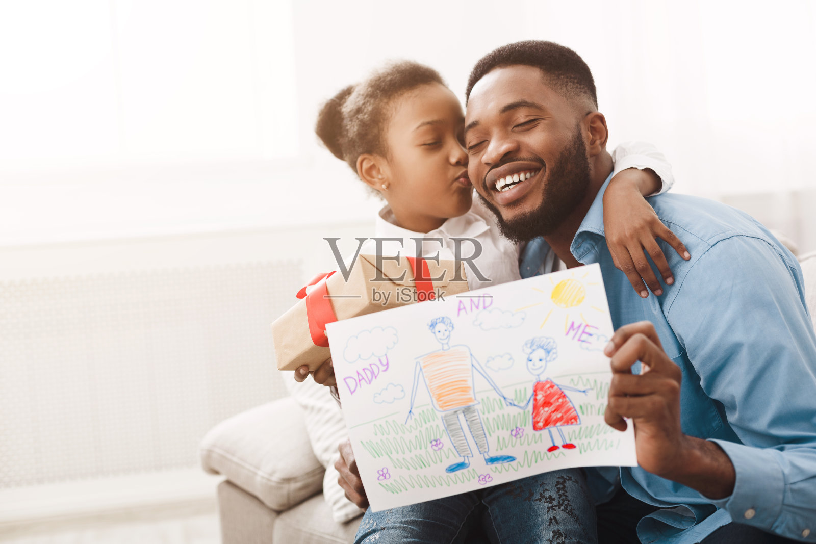 小女孩抱着爸爸，给爸爸手工画照片摄影图片