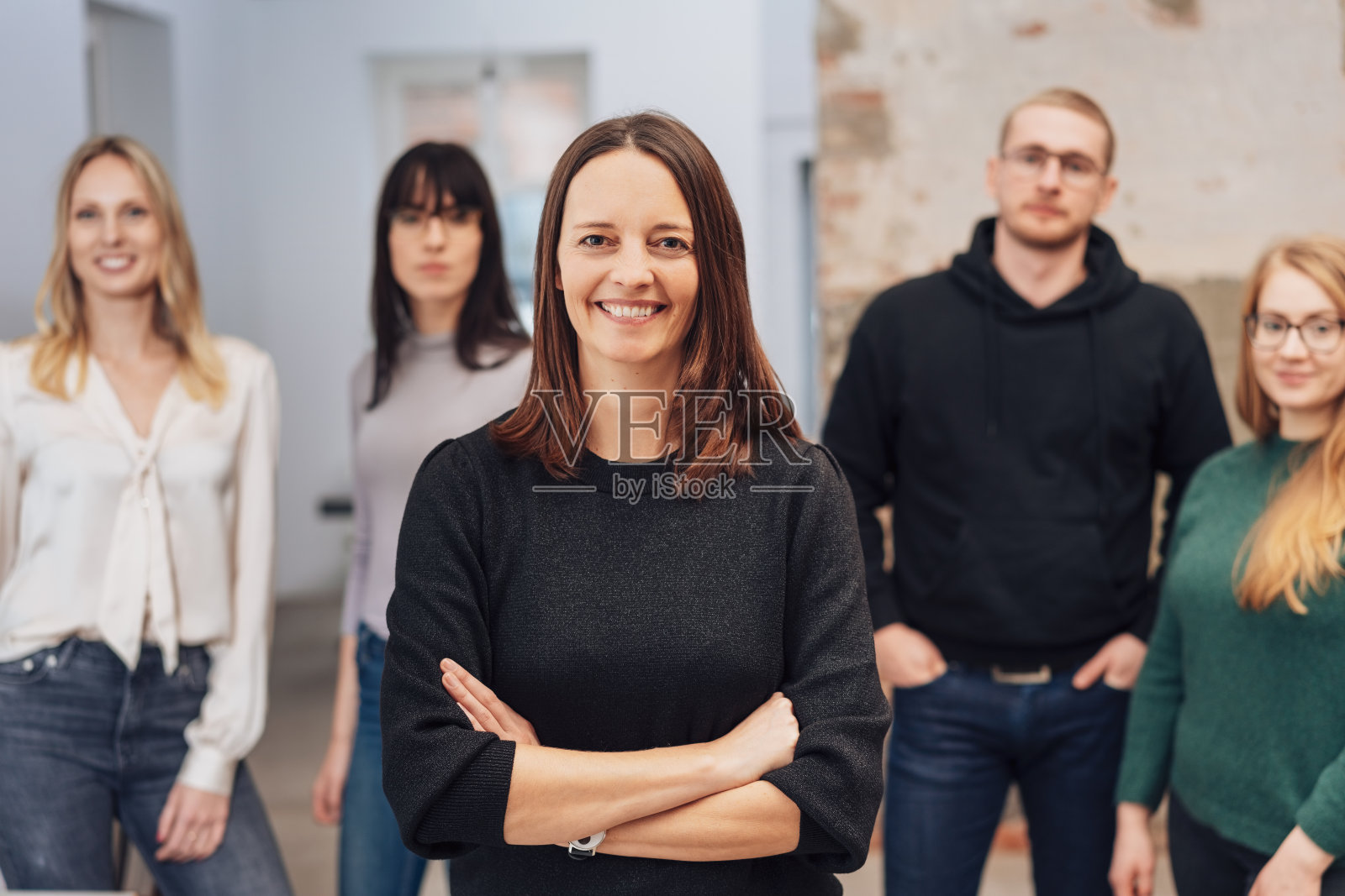 微笑着双臂交叉的女队长照片摄影图片