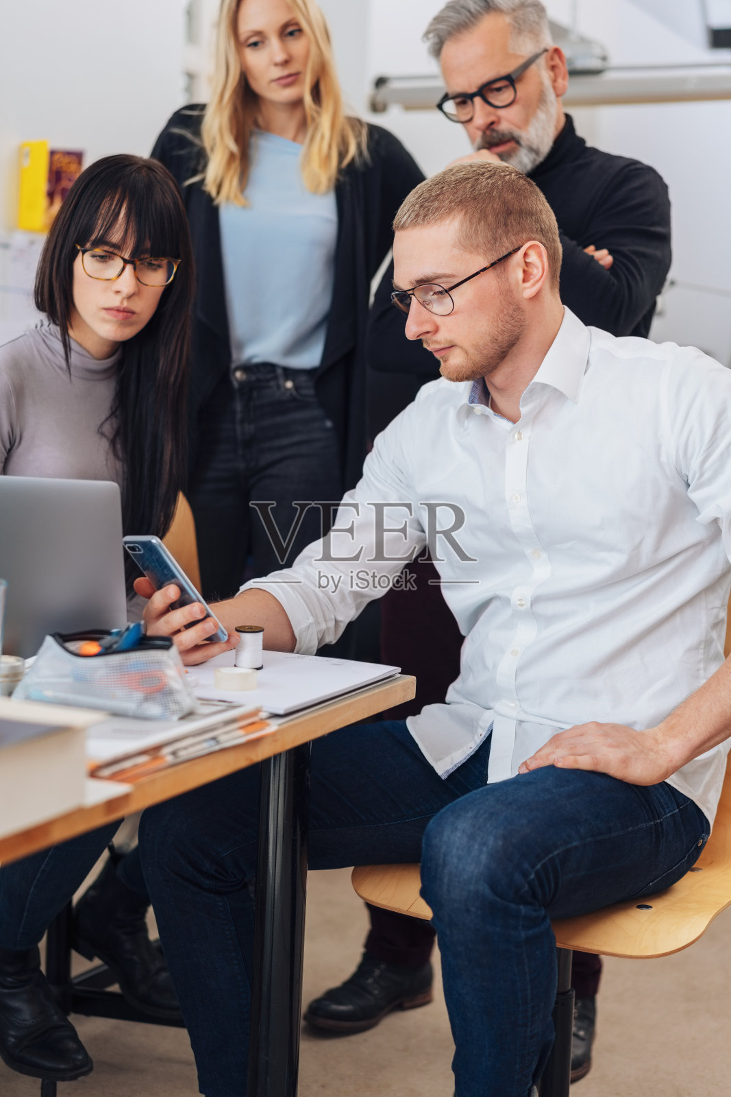 一个年轻人在看他手机上的信息照片摄影图片