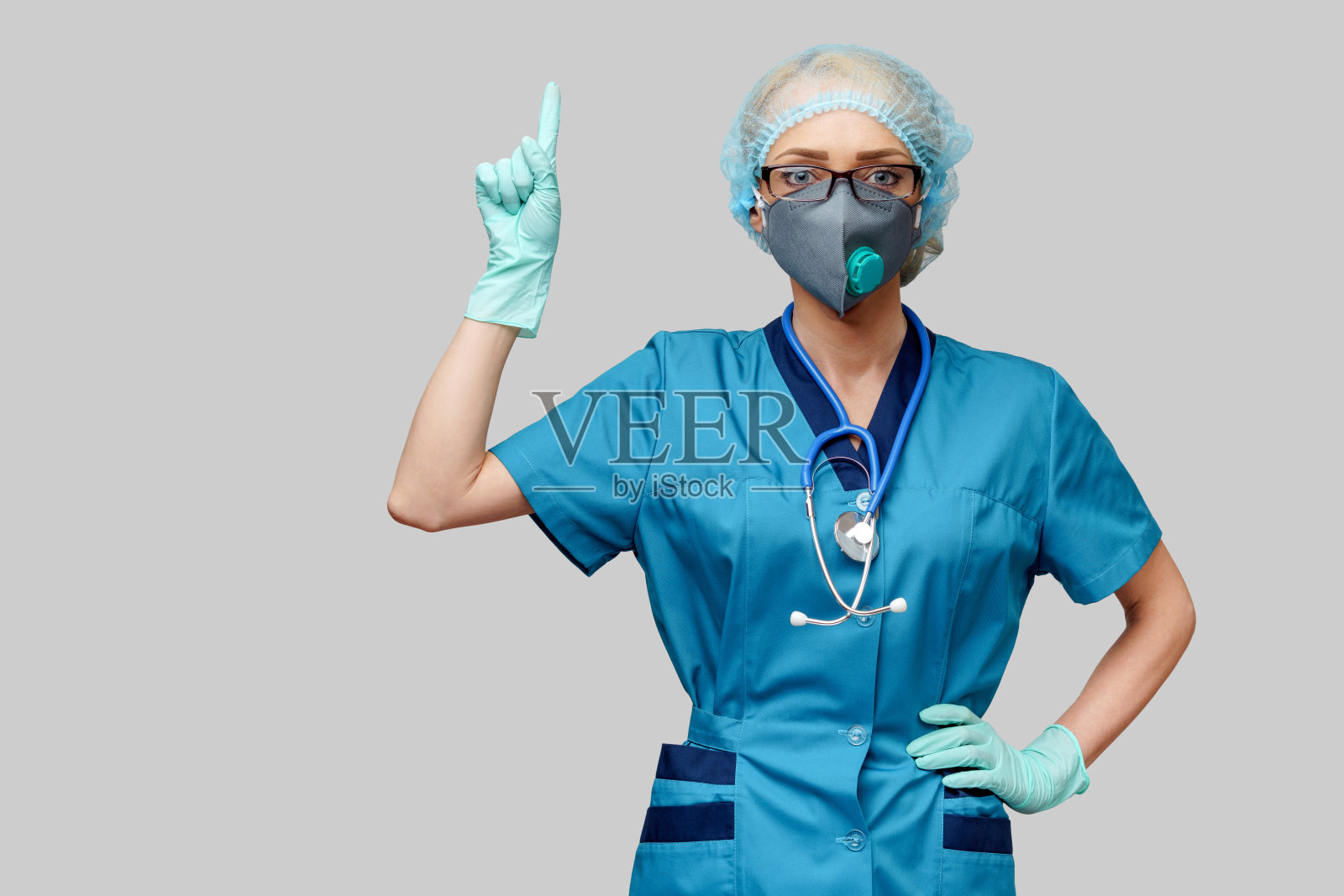 带听诊器的女医生，戴着防护口罩和乳胶手套，背景为浅灰色照片摄影图片