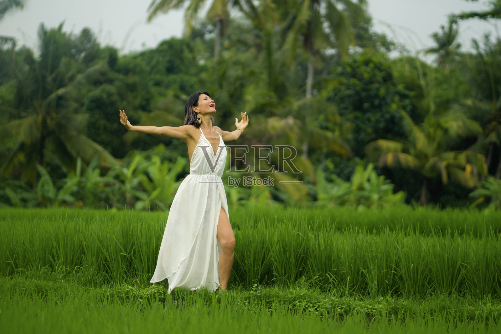 心灵和身体与自然的连接-中年有吸引力和快乐的亚洲日本女人在夏天的衣服享受田园诗般的热带目的地跳舞自由照片摄影图片