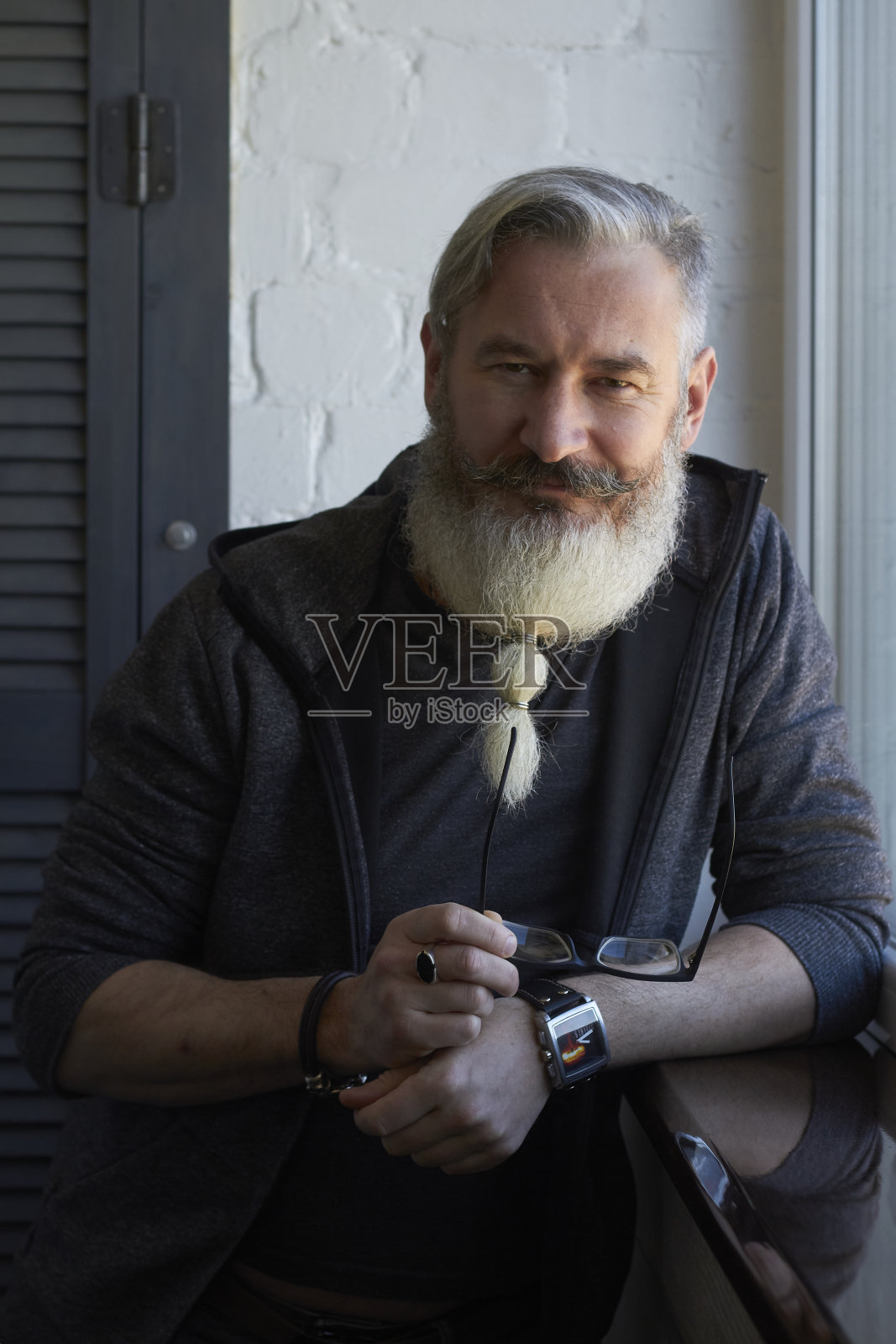 半长肖像的成熟灰色头发男子与原始的胡子在窗口背景，选择性焦点照片摄影图片