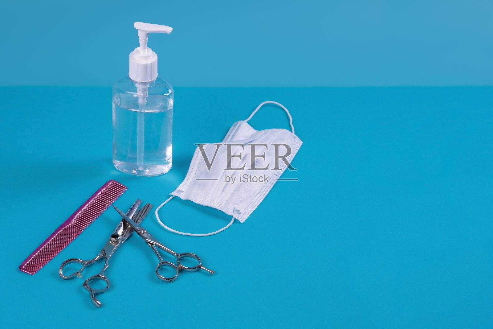 蓝色底色为面罩的美容套装和洗手液。理发店的新现实照片摄影图片