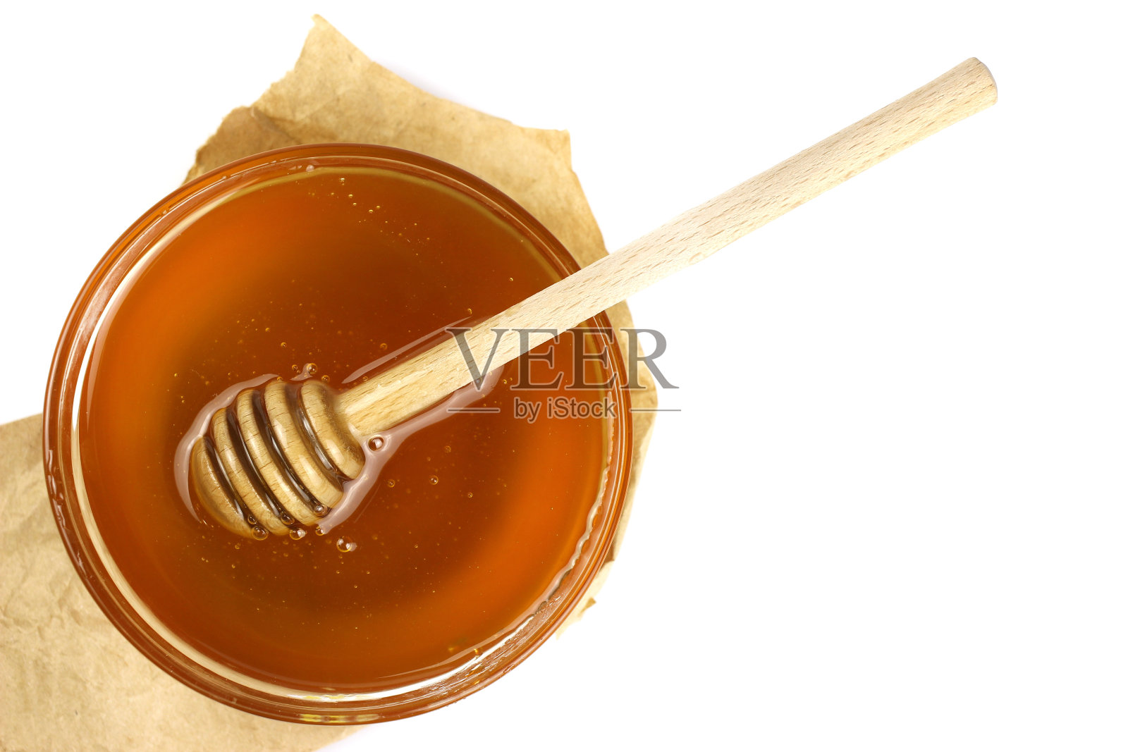 蜂蜜在碗与一根木棍孤立在白色的背景照片摄影图片