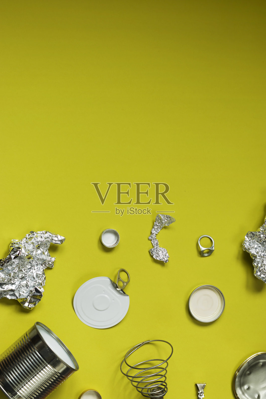 空金属制品、罐头、盖子等待加工。垃圾在橄榄色背景。照片摄影图片