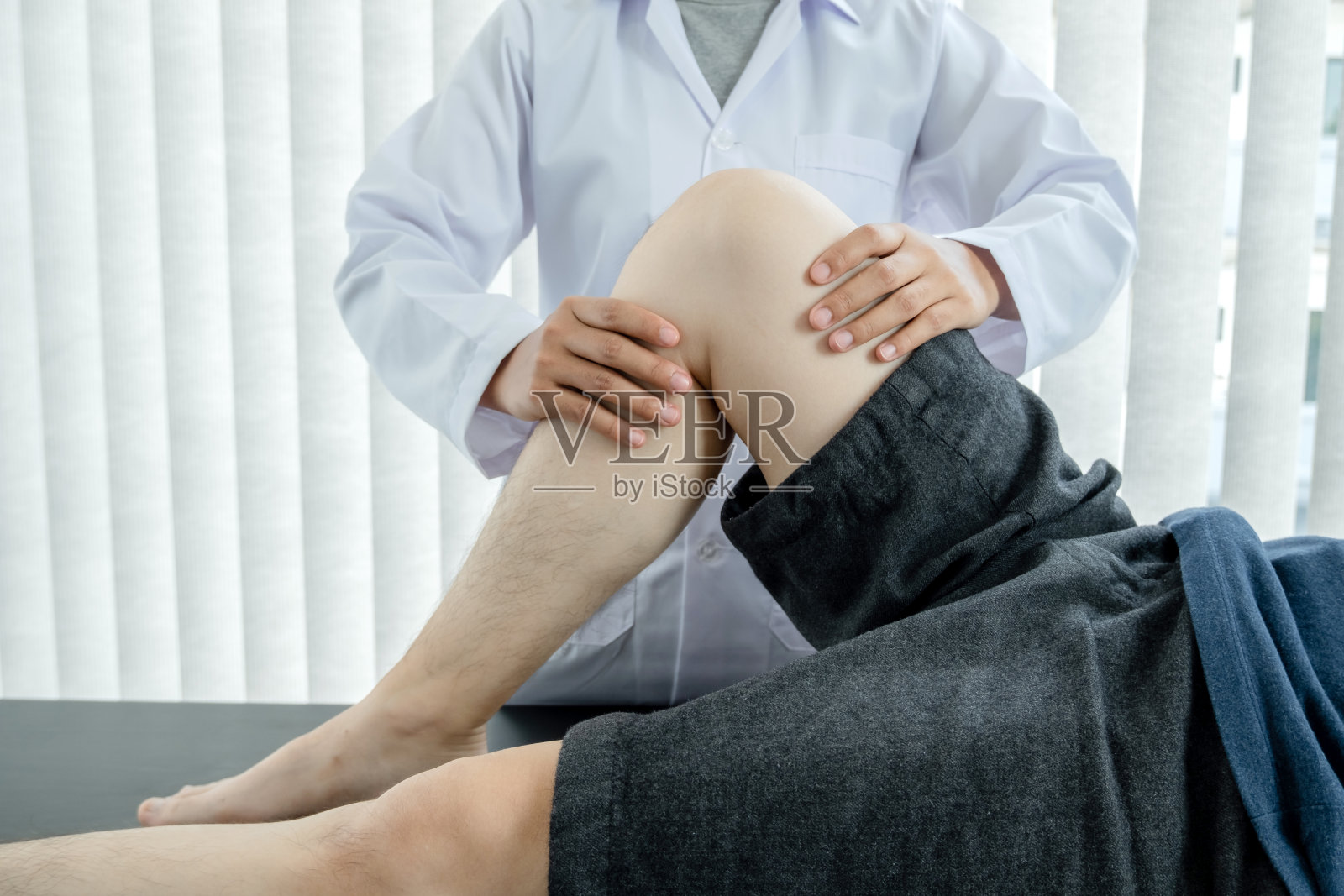 男性患者如有膝盖疼痛问题，会向理疗师求诊及治疗。康复理疗的概念照片摄影图片