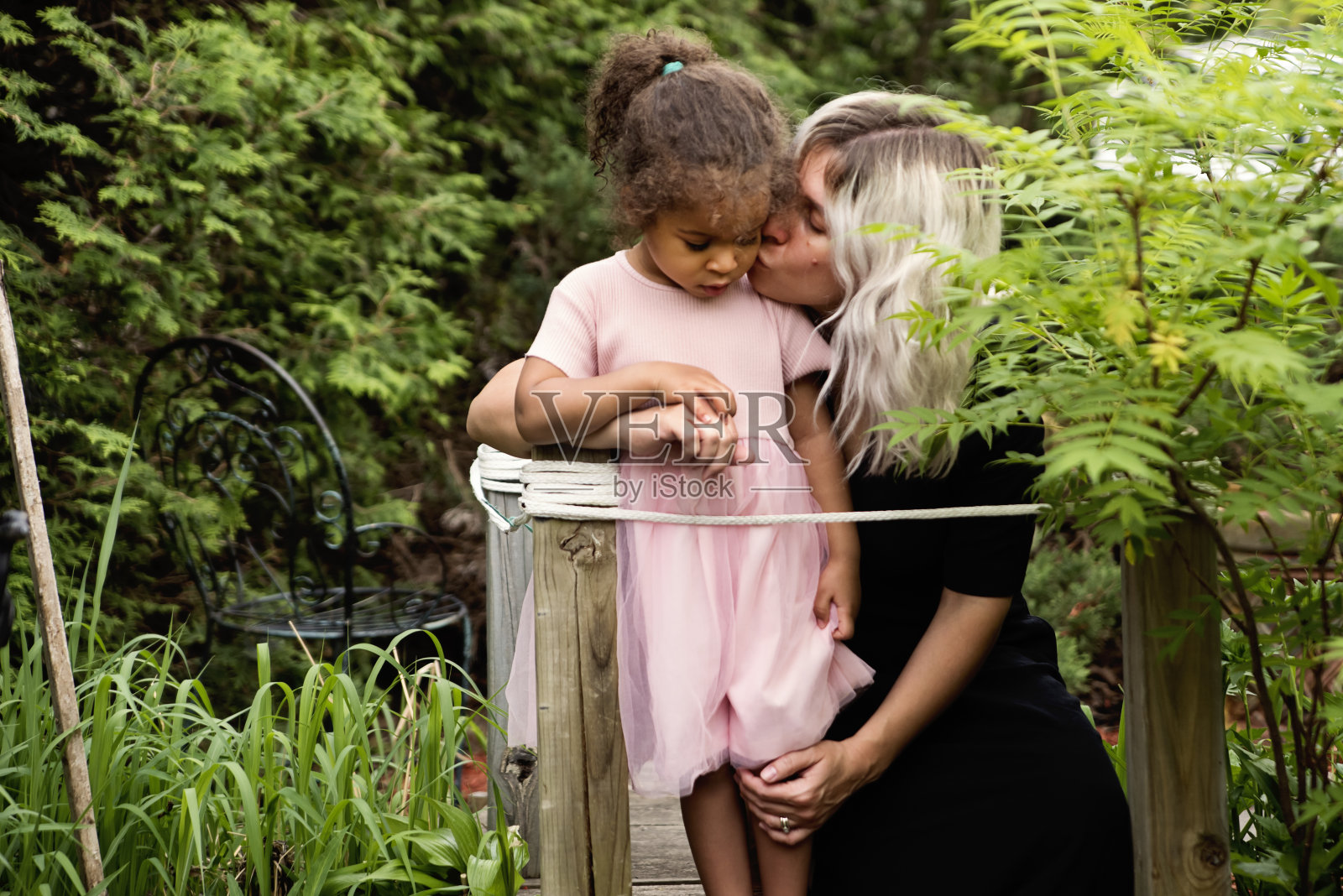 混血幼童和母亲在后院。照片摄影图片