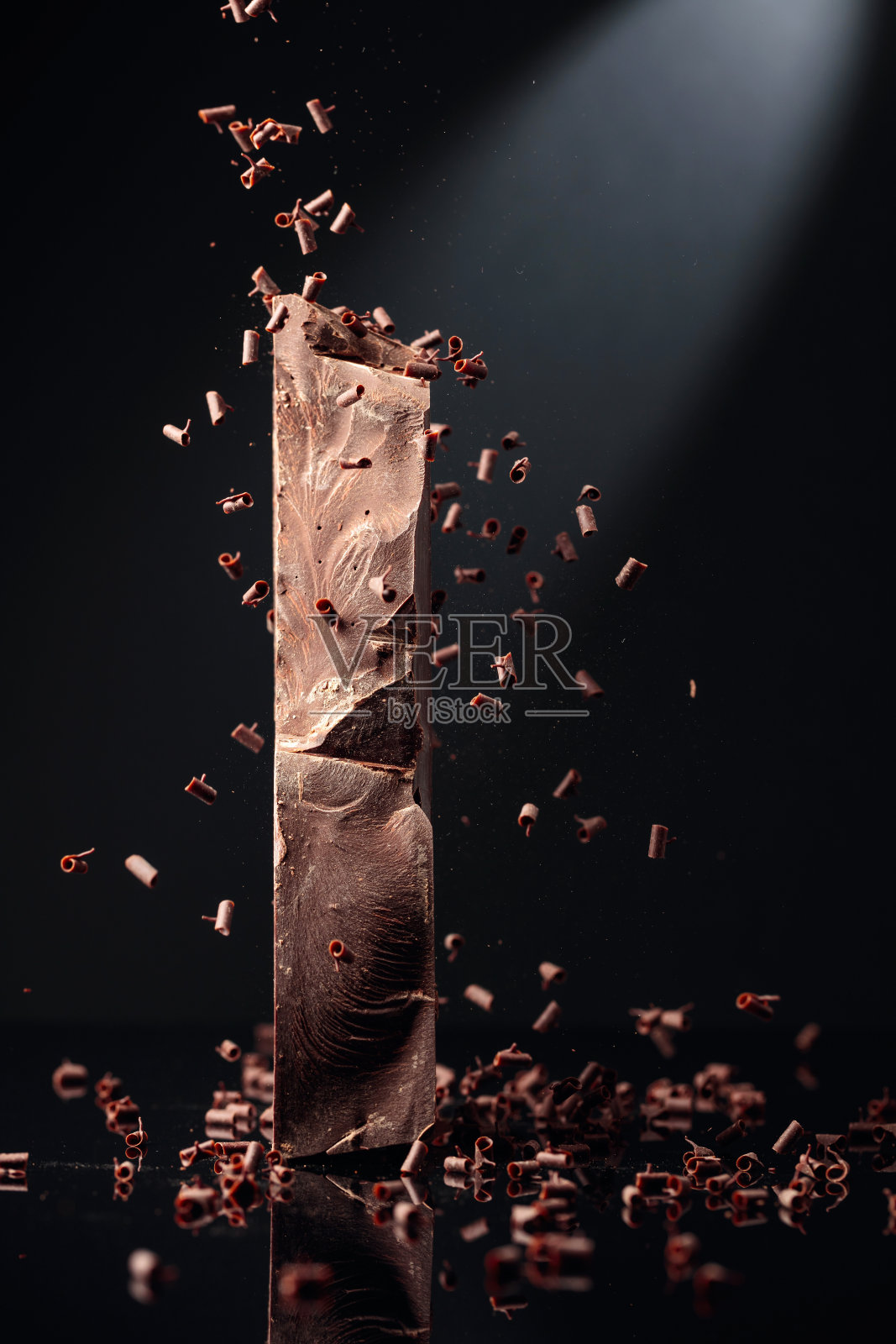 一块黑巧克力和掉落的巧克力屑。照片摄影图片