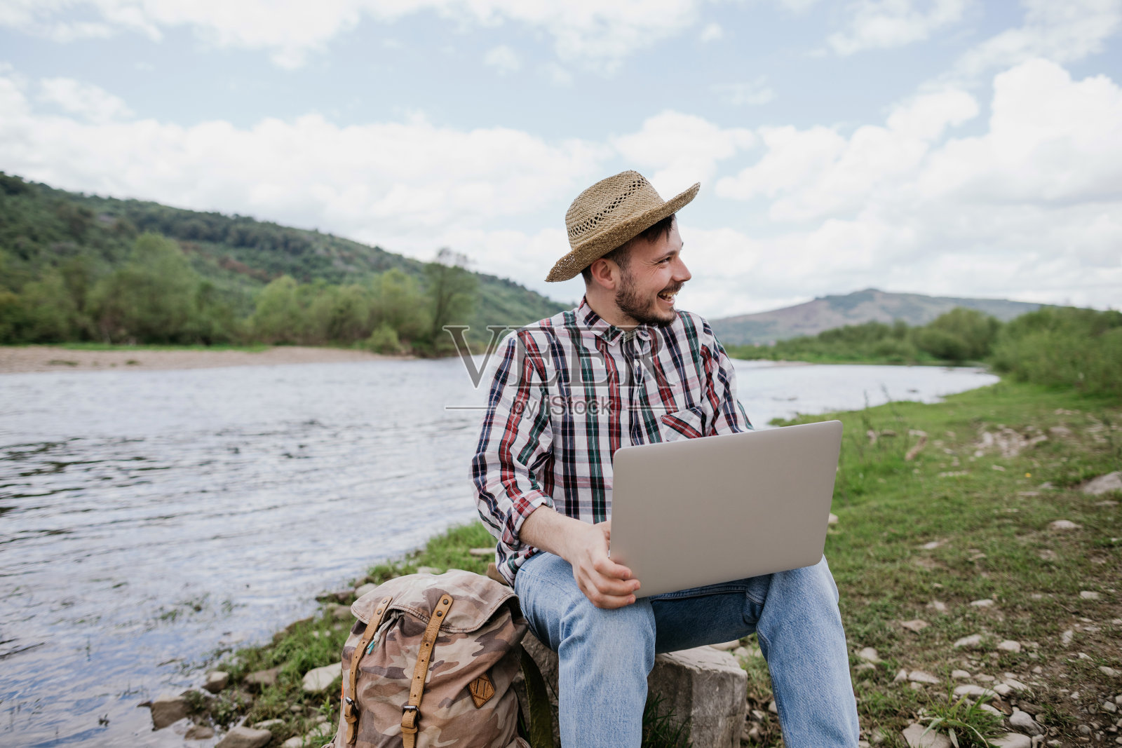 一个赶时髦的博主正在用笔记本电脑爬山。远程工作，永远在线照片摄影图片