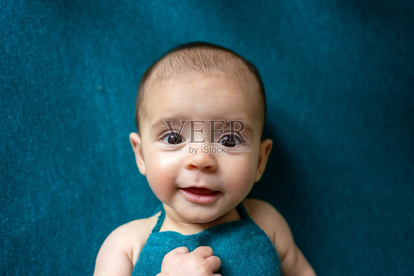 可爱的新生婴儿躺在蓝色的毯子上。婴儿在他的床上。新生儿的特写肖像。婴儿用品包装模板。托儿所。医学健康理念。照片摄影图片