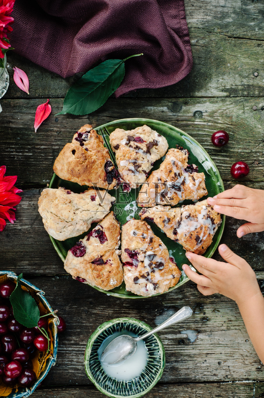 烤饼与燕麦，蔓越莓和胡桃木背景。前视图。孩子手里拿着饼干。照片摄影图片