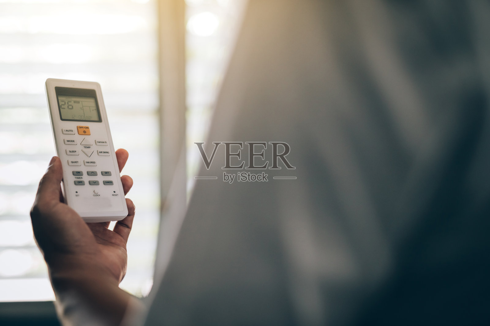 靠近一个拿着遥控器的年轻人的手照片摄影图片