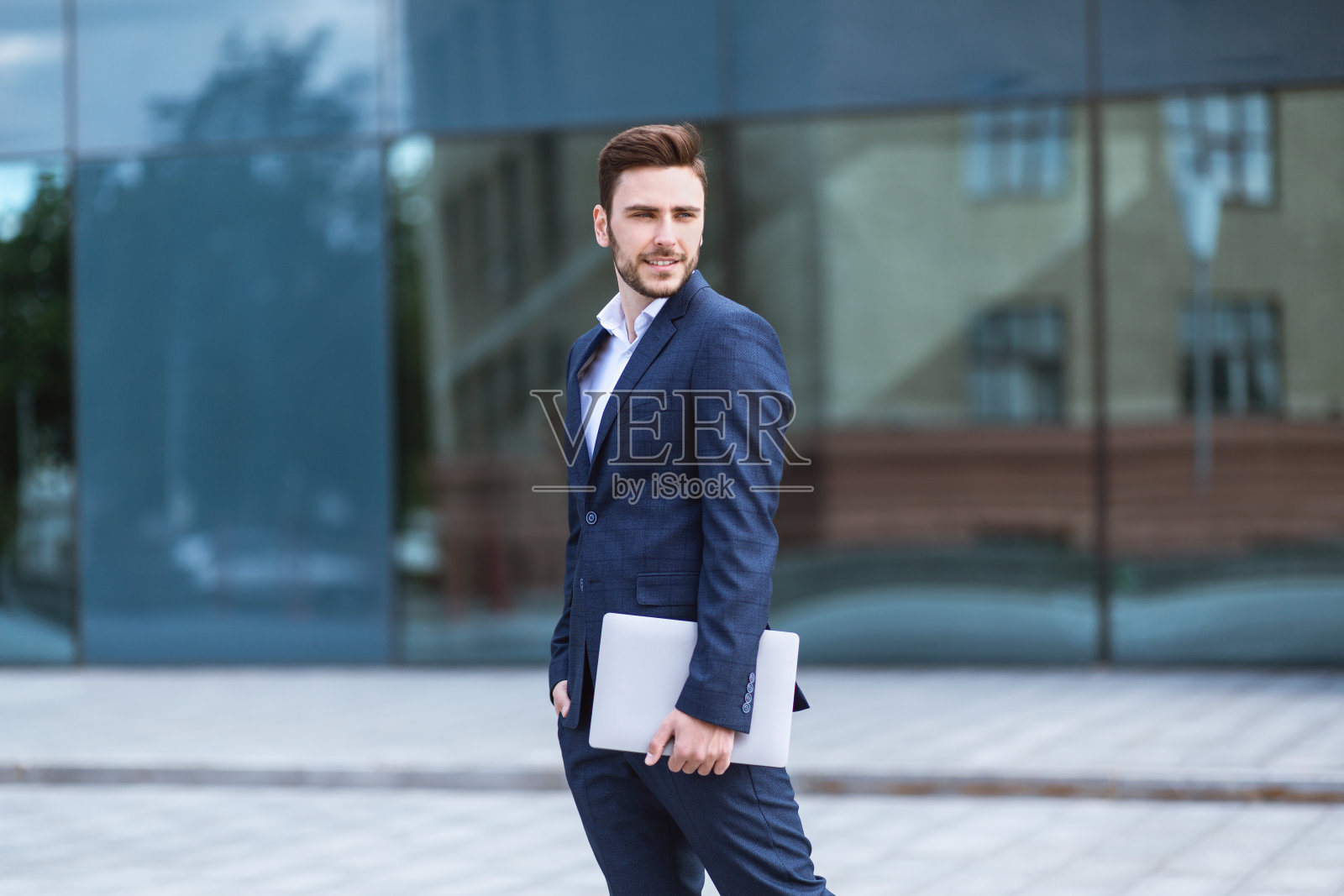 迷人的商人拿着平板电脑在城市街道上照片摄影图片