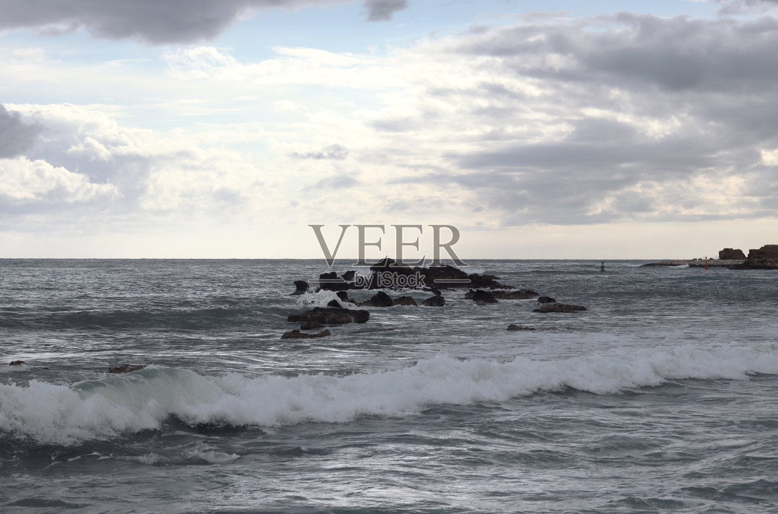 塞浦路斯帕福斯附近暴风雨中的暴风雨海。海浪冲击着突出海面的岩石。水滴飞到两米高。摘要海洋的力量照片摄影图片