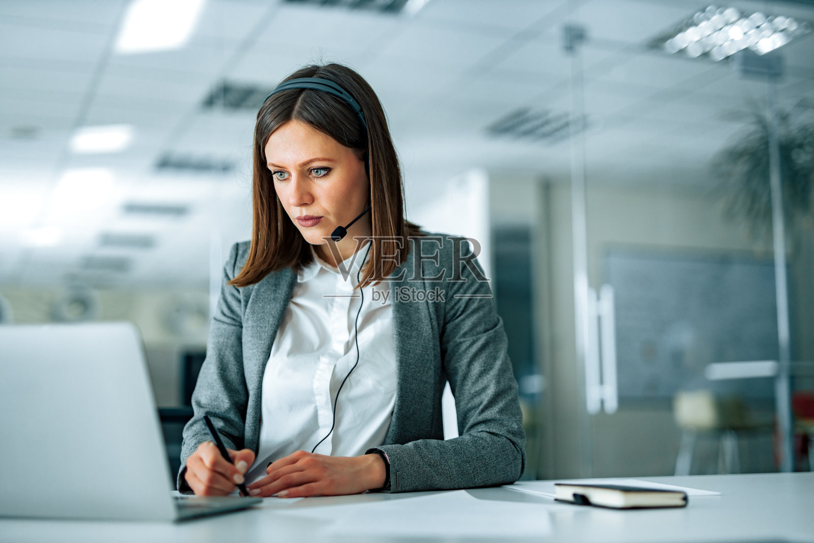 肖像专注的办公室工作人员在视频会议期间做笔记。照片摄影图片