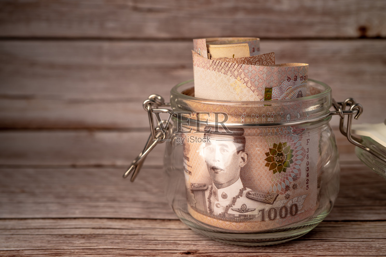 泰铢钞票以草罐木为背景，商业储蓄金融投资理念。照片摄影图片