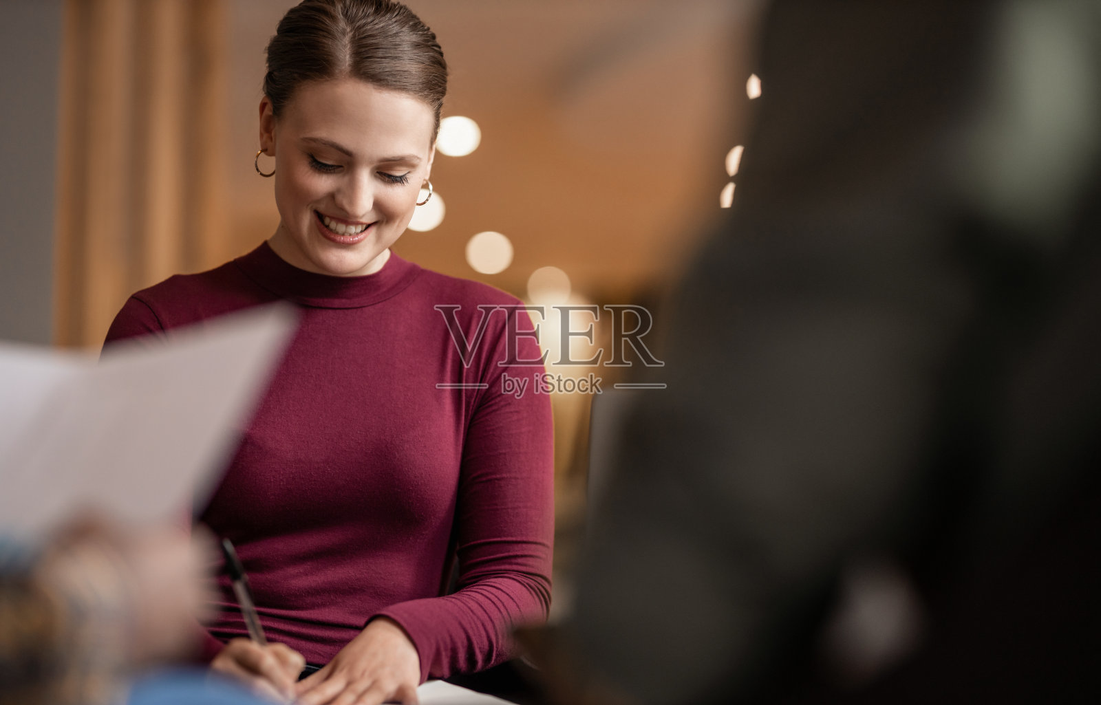 微笑的年轻女商人正在和办公室的同事开会照片摄影图片