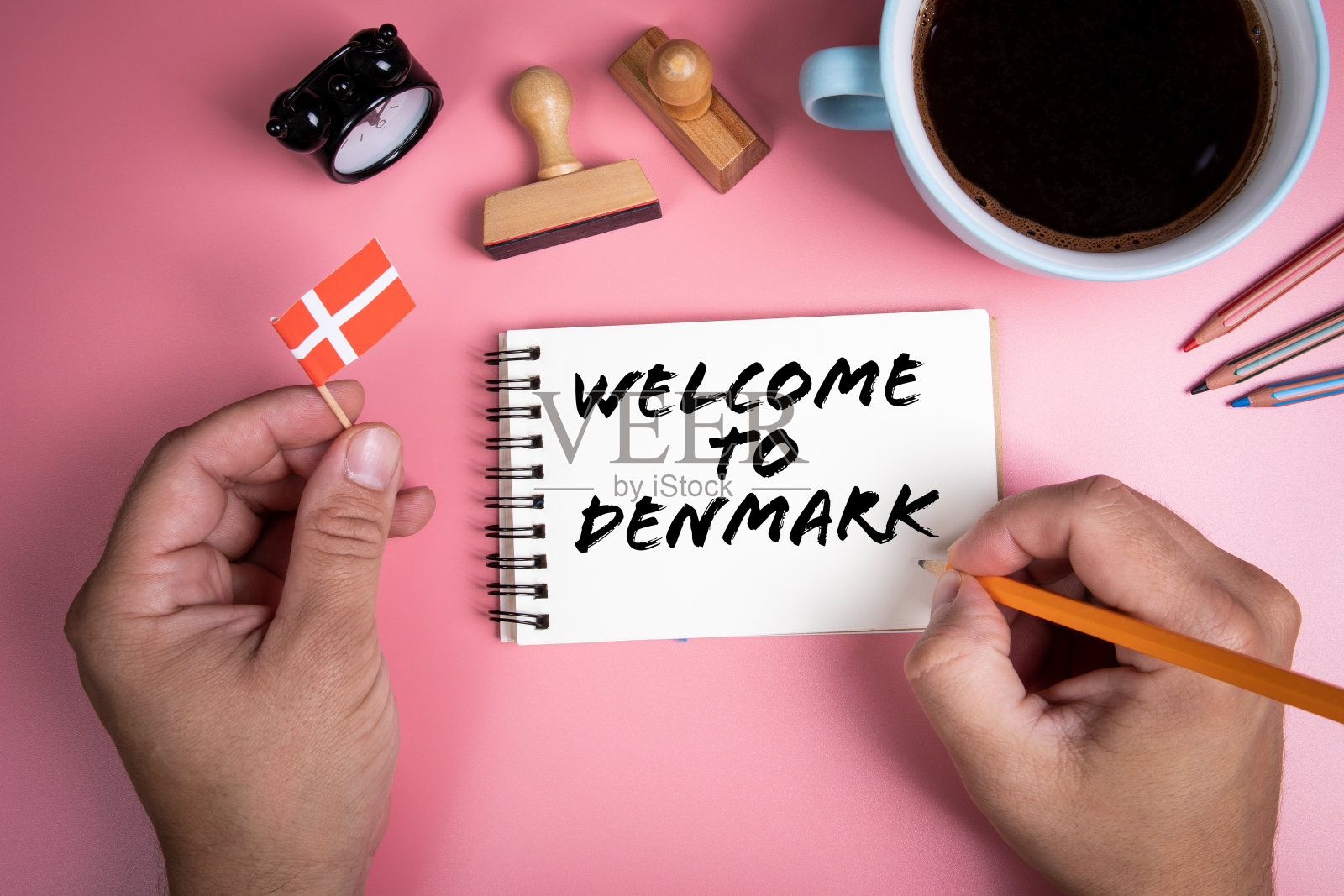 欢迎来到丹麦。咖啡杯，木制邮票和文具照片摄影图片