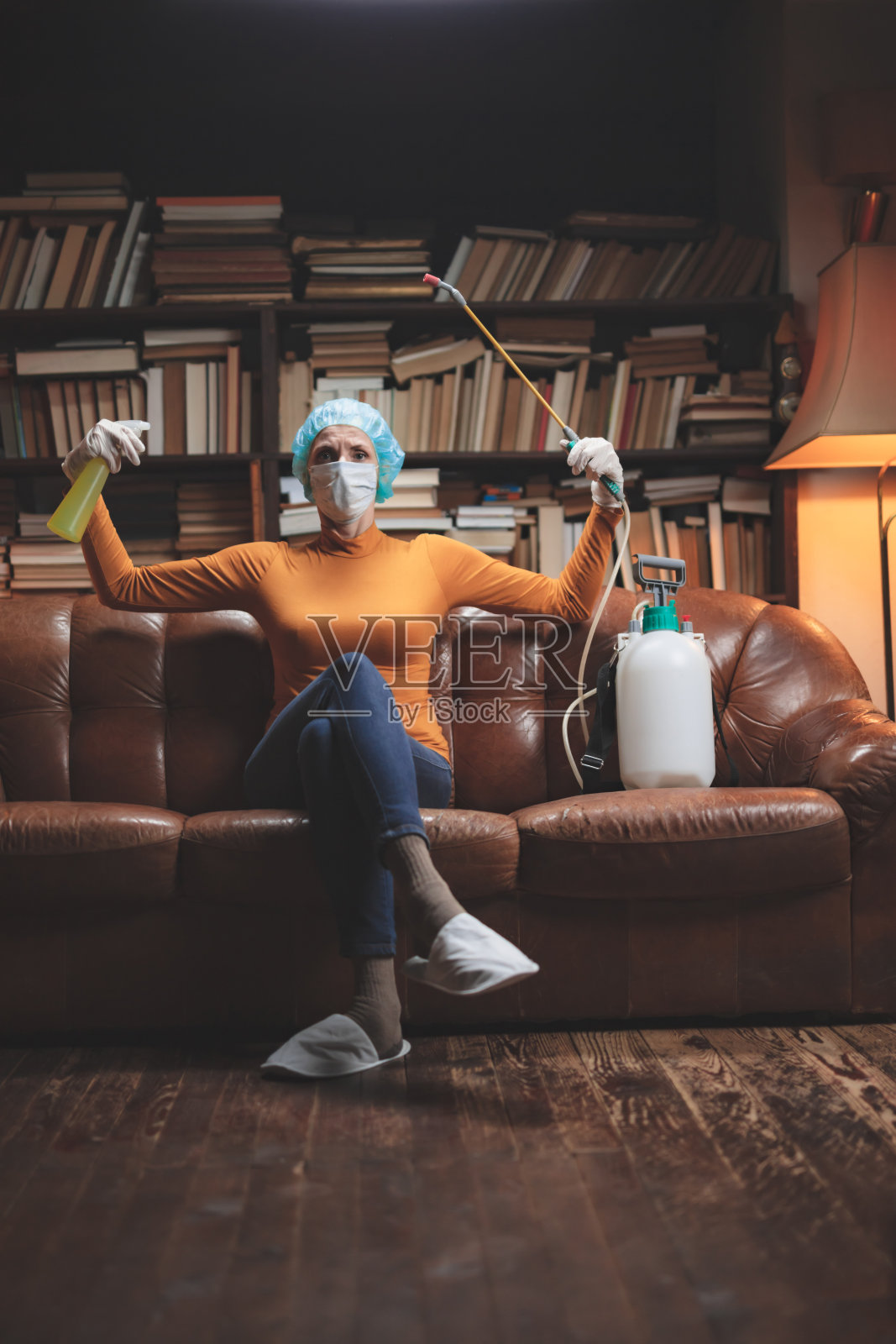 妇女用防护防毒口罩、化学去污喷雾器瓶在家隔离。照片摄影图片