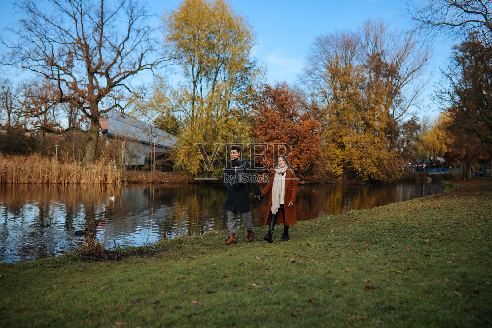 一对深情的情侣在秋天的公园散步照片摄影图片