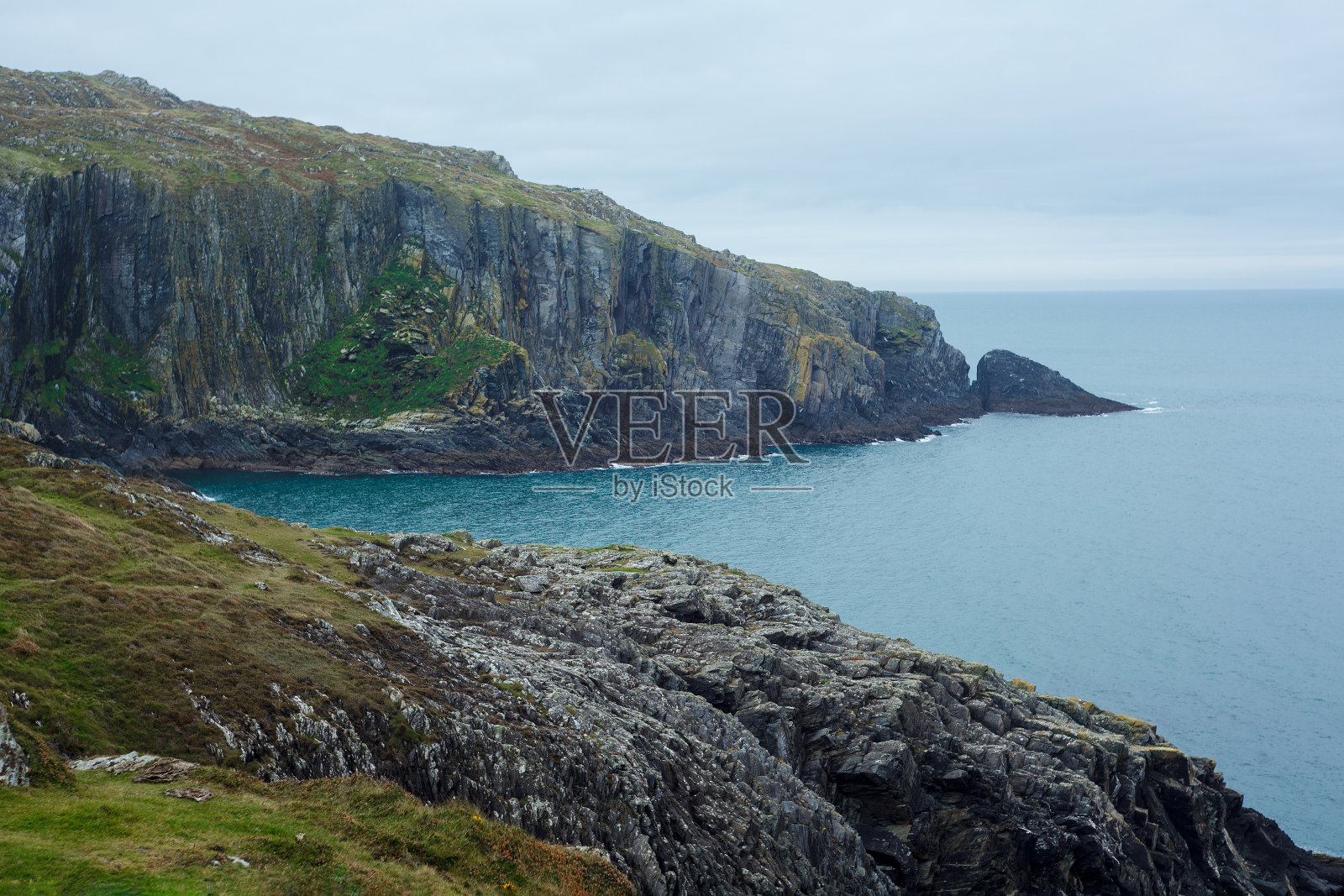 大西洋海岸的绿色岩石。爱尔兰的蓝色海水和灰色石头照片摄影图片