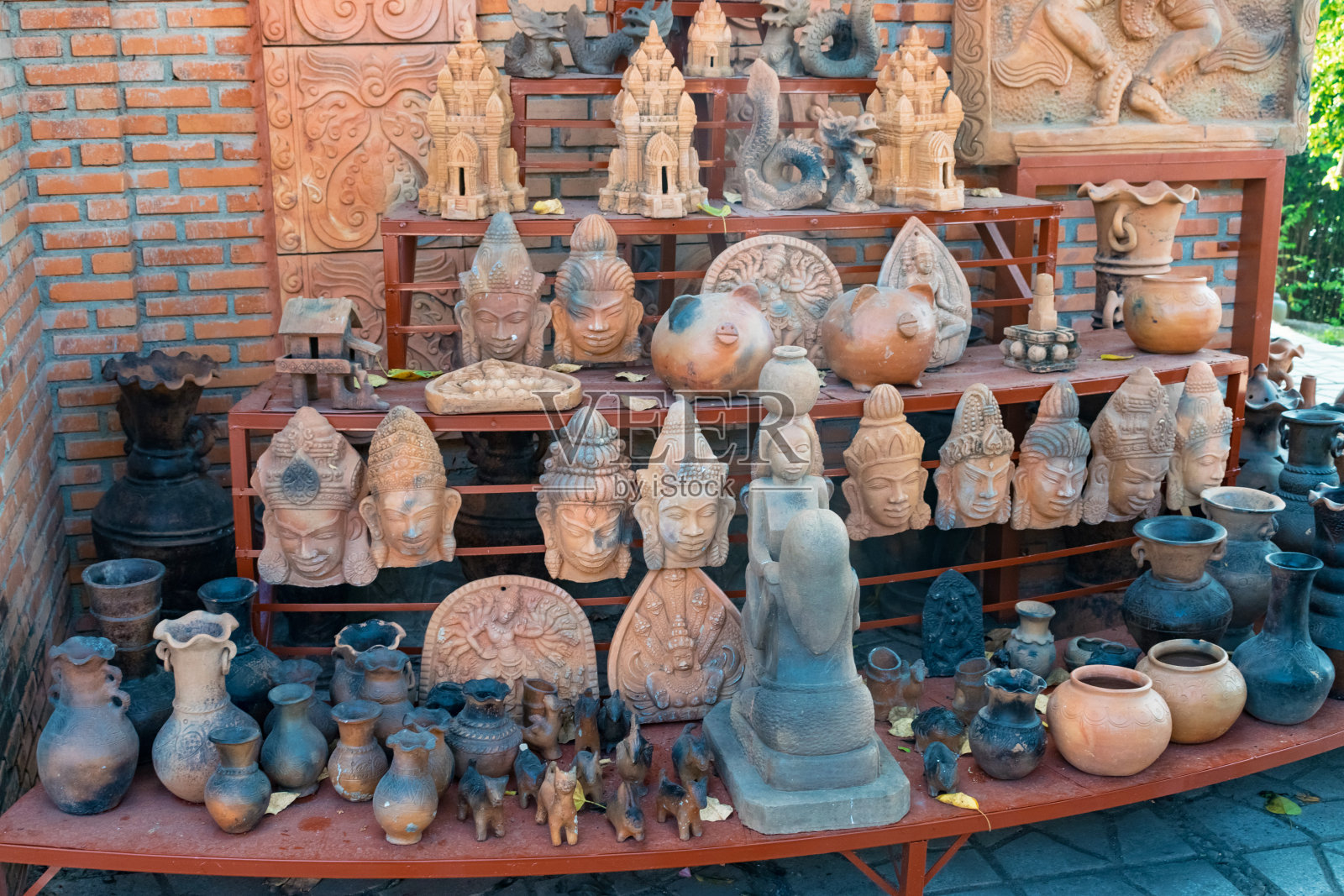 宗教粘土纪念品面具和水壶在亚洲的一个贸易商店的货架上照片摄影图片