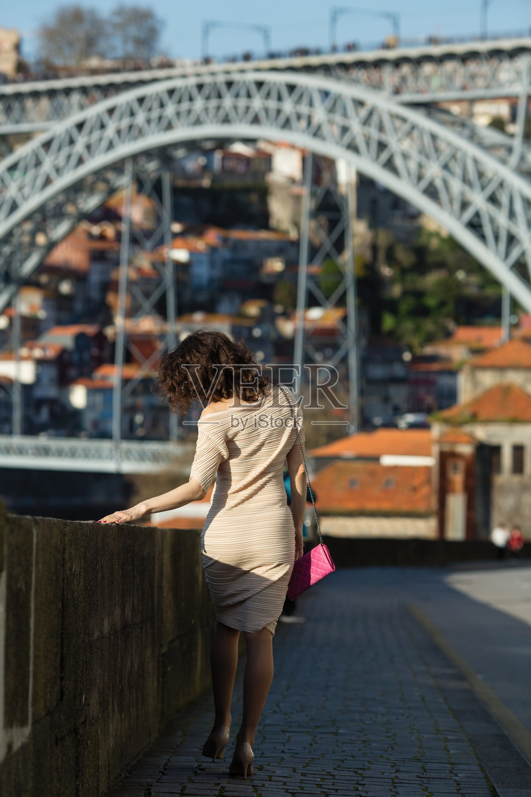 老妇人在老波尔图市中心多姆路易斯I桥附近的街道上。葡萄牙。照片摄影图片