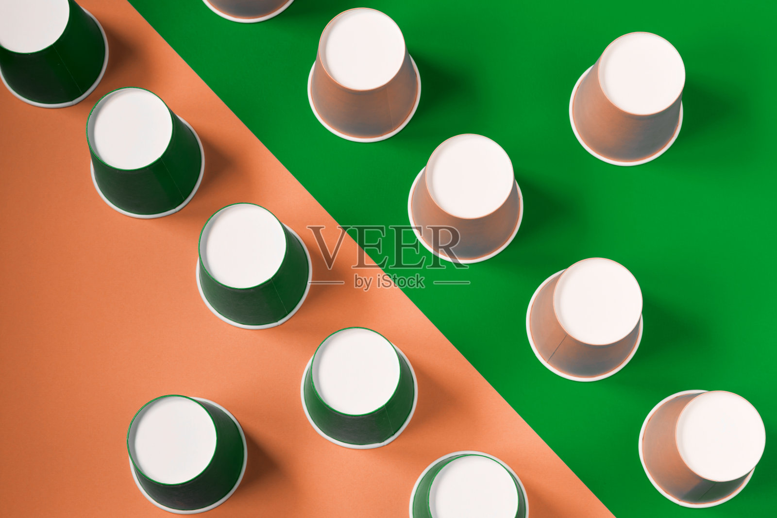 纸杯的图案位于对角线上的薄荷绿色背景。生态餐具。简约的风格。照片摄影图片