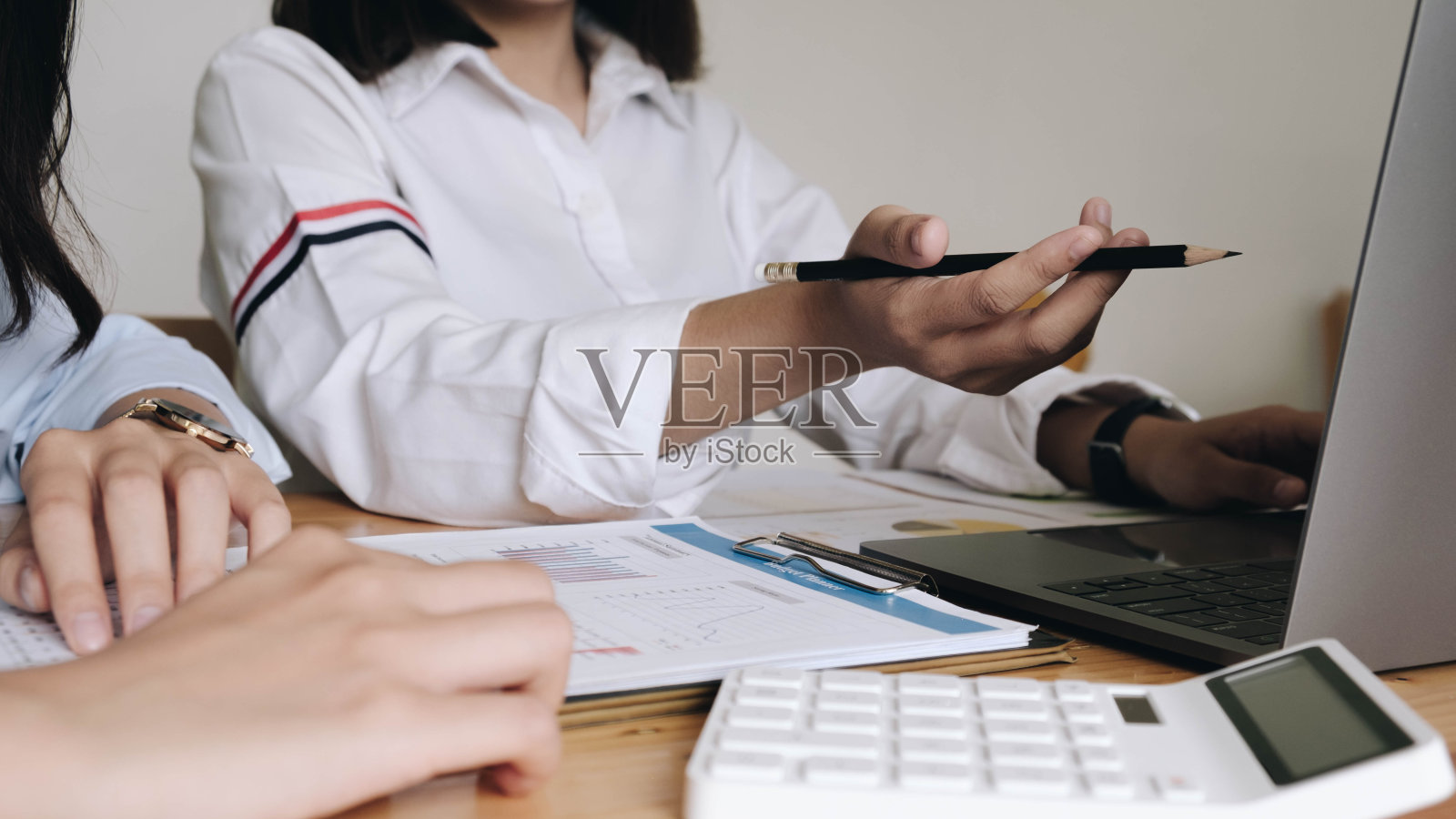 两个商人使用笔记本电脑和数字平板电脑讨论财务和营销解决方案。照片摄影图片